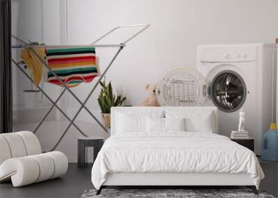 Clothes drying rack, laundry basket and washing machine indoors Wall mural