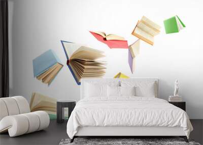 Colorful hardcover books flying on white background Wall mural