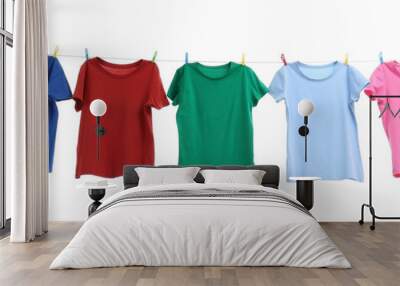 Colorful t-shirts drying on washing line isolated on white Wall mural