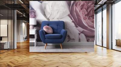 Comfortable armchair near wall with floral wallpaper. Stylish living room interior Wall mural