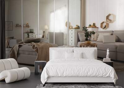 Comfortable grey sofa, ottoman and wardrobe with mirror doors in living room interior Wall mural