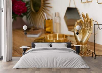 Composition with gold accessories and jewelry on dressing table near white wall Wall mural