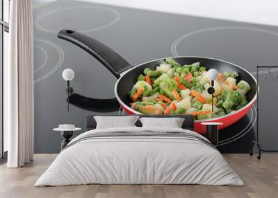 Cooking tasty frozen vegetable mix on induction stove Wall mural