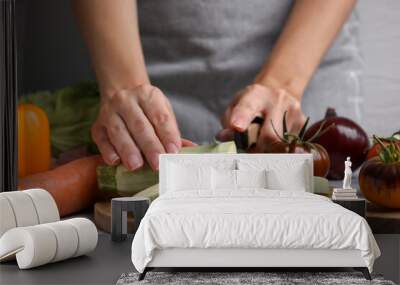 Cooking vegetable stew. Woman cutting zucchini at white marble table, closeup Wall mural