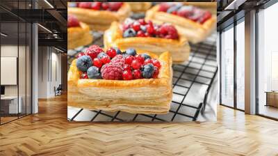 Cooling rack and fresh delicious puff pastry with sweet berries on white marble table, closeup Wall mural