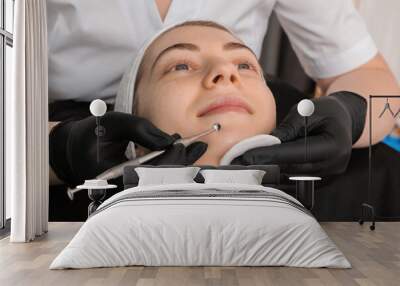 Cosmetologist using scrubber, closeup. Client having cleansing procedure Wall mural