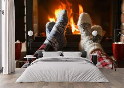 Couple in pajamas resting near fireplace indoors, closeup. Winter vacation Wall mural