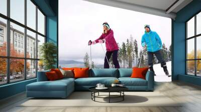 Couple of skiers on slope at resort. Winter vacation Wall mural