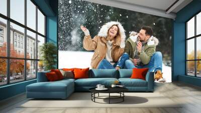 Couple spending time outdoors on snowy day. Winter vacation Wall mural