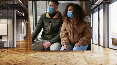 Couple with disposable masks on bus. Virus protection Wall mural