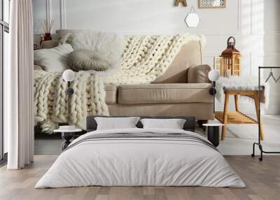 Cozy living room interior with beige sofa, knitted blanket and cushions Wall mural