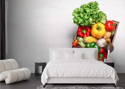 Crate with different fresh vegetables on light background, top view. Space for text Wall mural