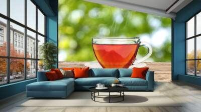 Cup of hot freshly brewed rooibos tea on wooden table outdoors Wall mural