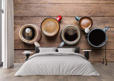 Cups of hot coffee on wooden table, flat lay Wall mural