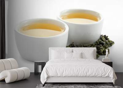 Cups of Tie Guan Yin oolong and tea leaves on white background Wall mural