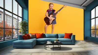 Cute girl with electric guitar on orange background Wall mural