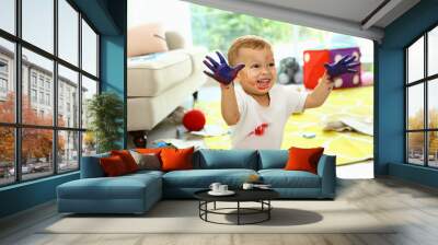 Cute little boy playing with paints on floor in living room Wall mural