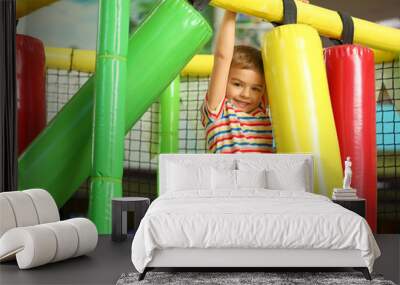 Cute little child playing at indoor amusement park Wall mural