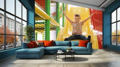 Cute little child playing at indoor amusement park Wall mural