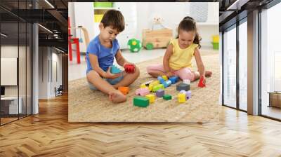 Cute little children playing with colorful blocks on floor indoors. Educational toy Wall mural