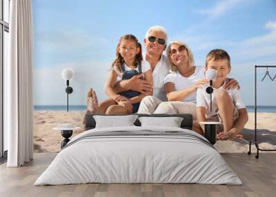 Cute little children with grandparents spending time together on sea beach Wall mural