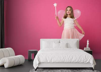 Cute little girl in fairy costume with wings and magic wand on pink background. Space for text Wall mural