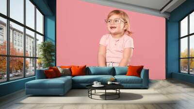 Cute little girl in glasses on pink background. Space for text Wall mural