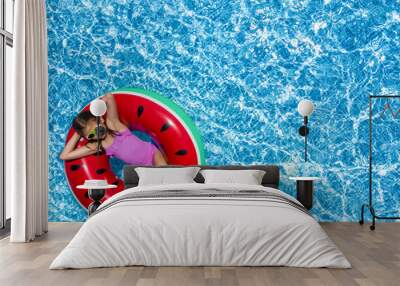 Cute little girl with inflatable ring in swimming pool, top view. Space for text Wall mural