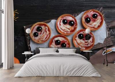 Cute monster tartlets served on black wooden table, flat lay with space for text. Halloween party food Wall mural