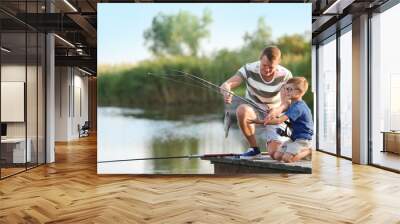 Dad and son fishing together on sunny day Wall mural