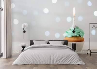 Delicious birthday cupcake with burning candle and space for text on blurred lights background Wall mural