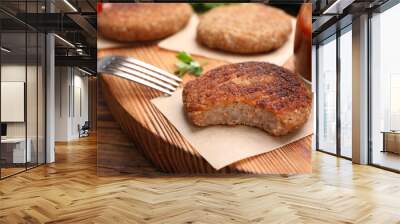 Delicious bitten vegan cutlet on wooden table, closeup Wall mural