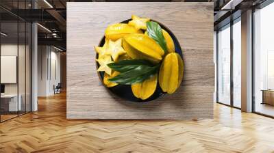 Delicious carambola fruits on wooden table, top view Wall mural