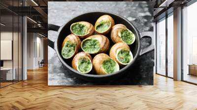 Delicious cooked snails in baking dish on grey textured table, closeup Wall mural