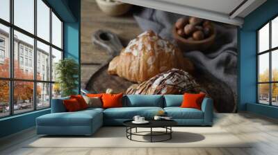 Delicious croissants with chocolate and nuts on wooden table Wall mural