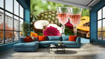 Delicious exotic fruits and wine on light blue wooden table Wall mural