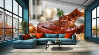 Delicious fried chicken wings served with sauce on table, closeup Wall mural