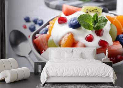 Delicious fruit salad with yogurt in bowl on table, closeup Wall mural