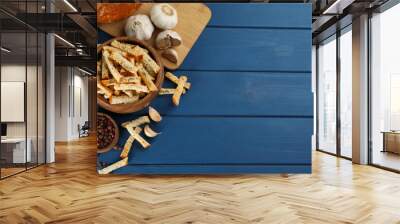 Delicious hard chucks and garlic on blue wooden table, flat lay. Space for text Wall mural