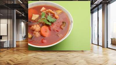 Delicious homemade stew in bowl on green background, closeup Wall mural