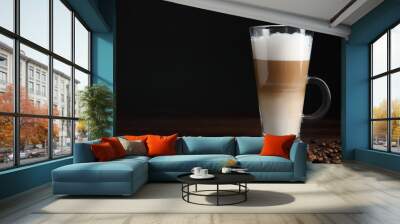 Delicious latte macchiato and coffee beans on wooden table, space for text Wall mural