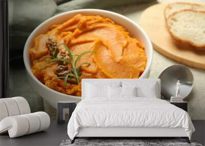 Delicious mashed sweet potatoes with walnuts, rosemary, spoon and bread on light table, closeup Wall mural