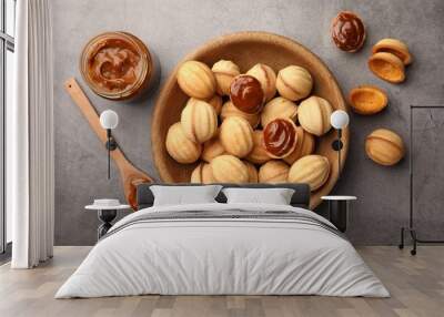 Delicious nut shaped cookies with boiled condensed milk on gray textured table, flat lay Wall mural