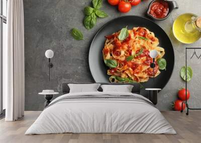 Delicious pasta with tomato sauce, basil and products on grey textured table, flat lay. Space for text Wall mural