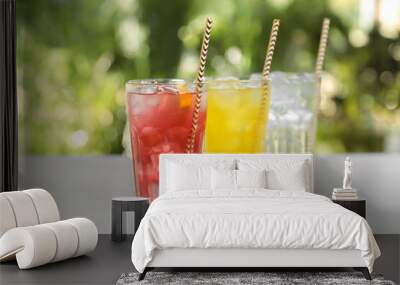 Delicious refreshing drinks in glasses on grey table outdoors Wall mural