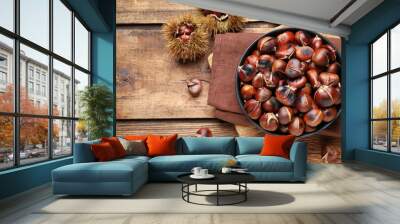 Delicious roasted edible chestnuts on wooden table, flat lay Wall mural