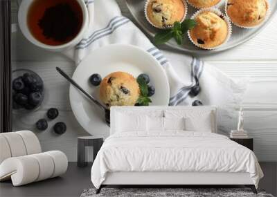 Delicious sweet muffins with blueberries and mint served on white wooden table, flat lay Wall mural