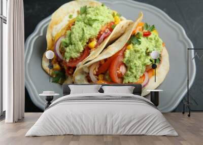 Delicious tacos with guacamole, meat and vegetables on black table, closeup Wall mural