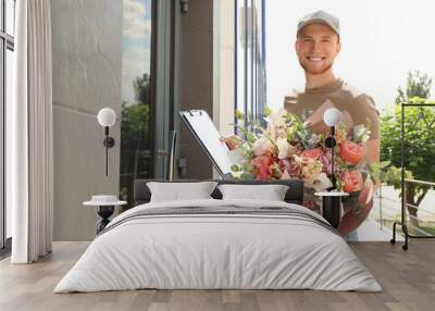 Delivery man with beautiful flower bouquet near front door Wall mural