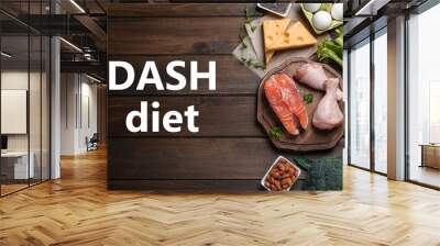 Dietary approaches to stop hypertension. Many different healthy food and words Dash diet on wooden table, flat lay Wall mural